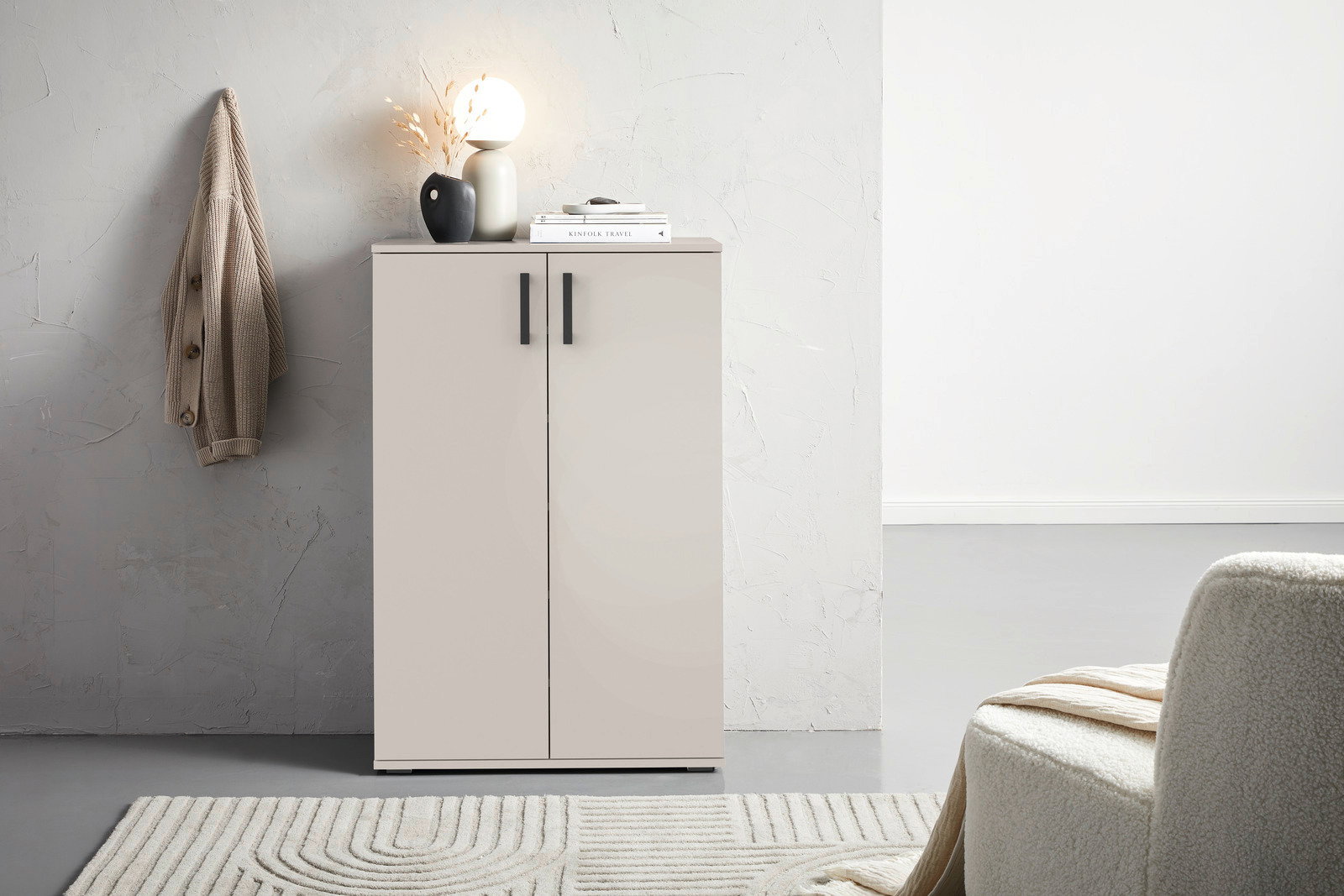 Moderner Schuhschrank in hellem Raum, frontal fotografiert, mit Dekoration auf der Oberseite.