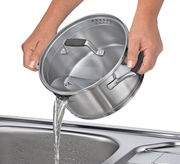 Topf aus Edelstahl mit Deckel, der Wasser in ein Spülbecken gießt, seitliche Perspektive