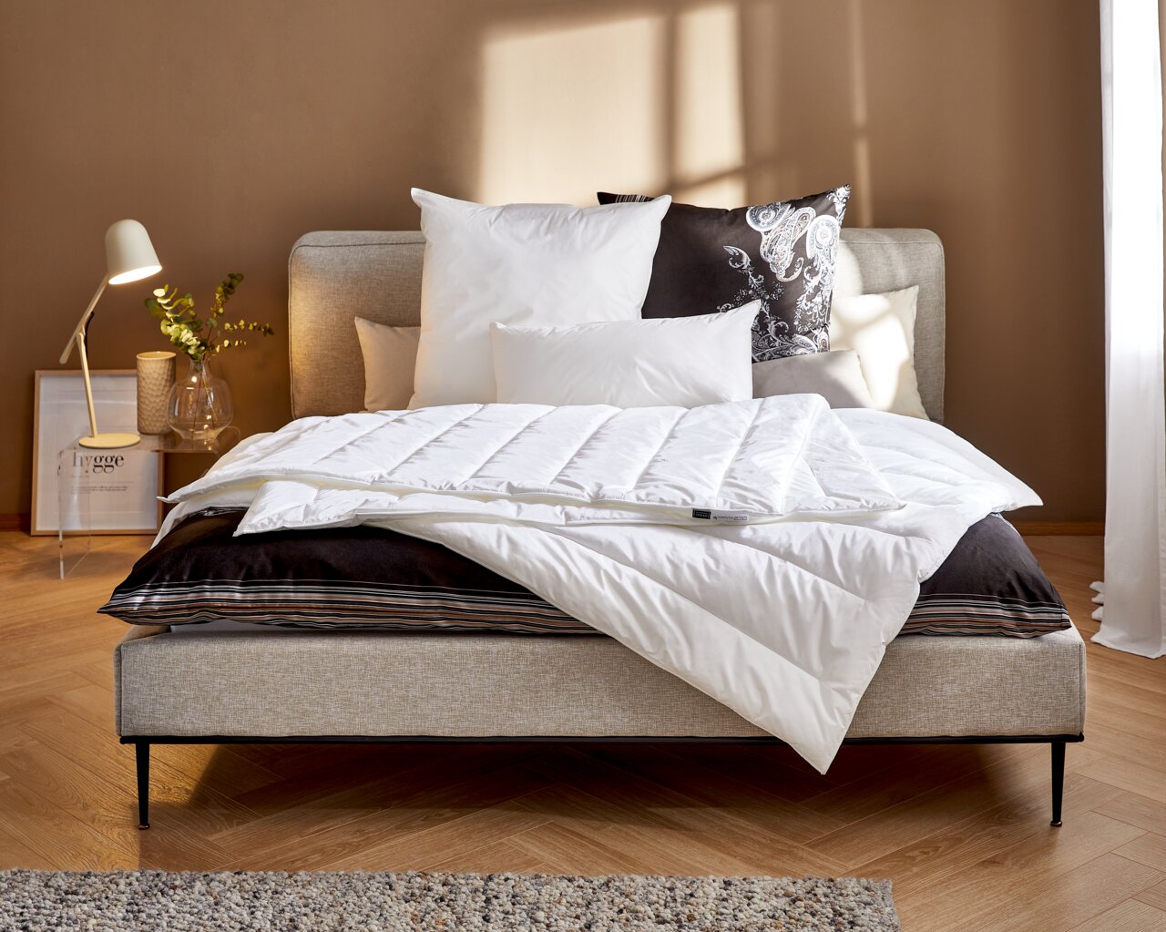 Gemütliches Schlafzimmer mit der Vegan Dream Leicht Bettdecke von Centa Star auf einem stilvollen Bett, seitliche Perspektive.