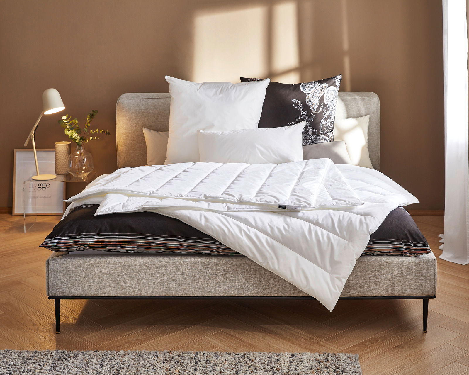 Gemütliches Schlafzimmer mit der Vegan Dream Leicht Bettdecke von Centa Star auf einem stilvollen Bett, seitliche Perspektive.