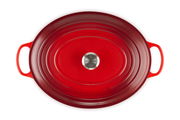 Vogelperspektive auf einen ovalen, kirschroten Bräter mit zwei Griffen und einem silbernen Knauf auf dem Deckel.