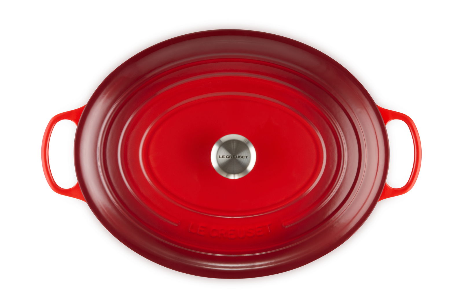 Vogelperspektive auf einen ovalen, kirschroten Bräter mit zwei Griffen und einem silbernen Knauf auf dem Deckel.