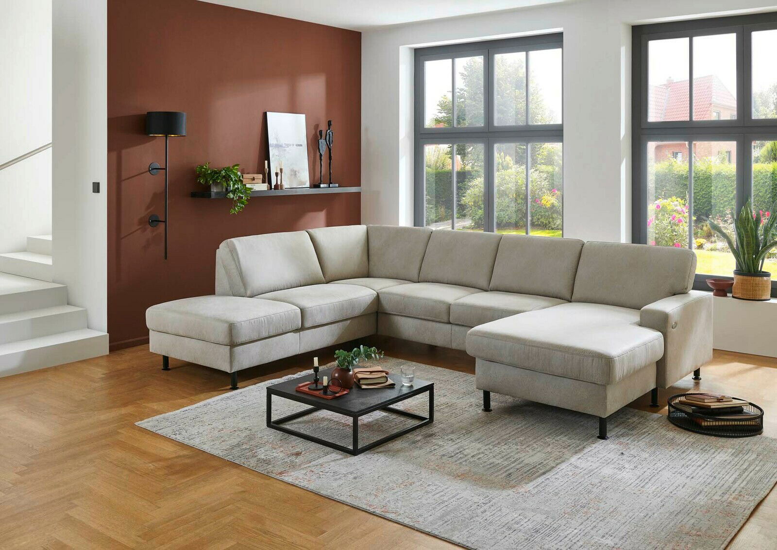 Moderne Polsterrundecke in hellem Beige, L-Form, mit Blick auf ein stilvoll eingerichtetes Wohnzimmer mit großen Fenstern.