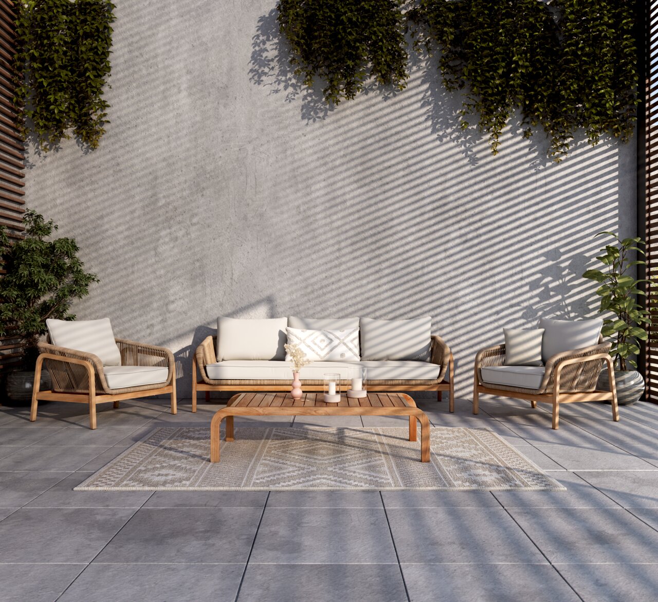 Loungegarnitur-Set aus Holz und Rattan mit beigen Kissen, bestehend aus einem Sofa, zwei Sesseln und einem niedrigen Tisch, auf einer Terrasse mit Pflanzen im Hintergrund, aus frontaler Perspektive.