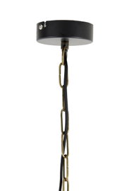 Close-up van de ophanging van een hanglamp met een zwarte kap en een gouden ketting.