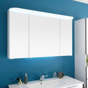 Moderne weiße Badkombination mit beleuchtetem Spiegelschrank, frontal vor einer blauen Wand montiert.