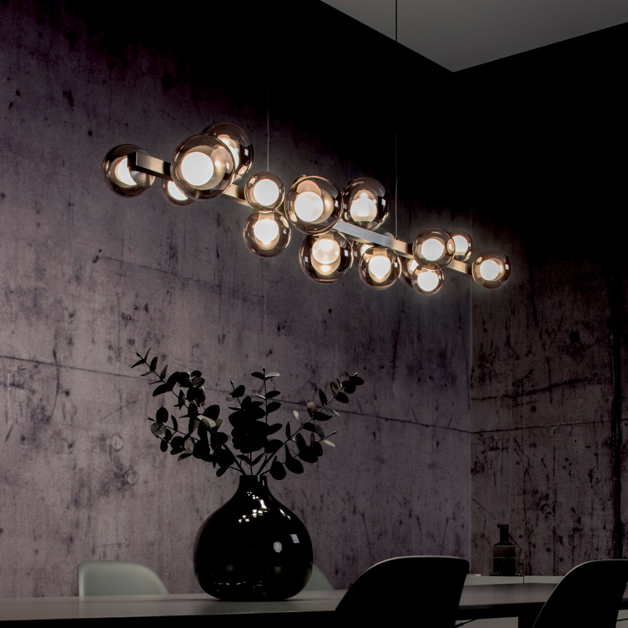 Moderne LED-Pendelleuchte mit mehreren kugelförmigen Leuchten, hängend über einem Esstisch in einem stilvoll eingerichteten Raum, seitliche Perspektive.
