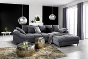 Graue Rundecke (L) in einem modernen Wohnzimmer, seitliche Perspektive, mit dekorativen Kissen und Decke, umgeben von stilvollen Möbeln und großen Fenstern.