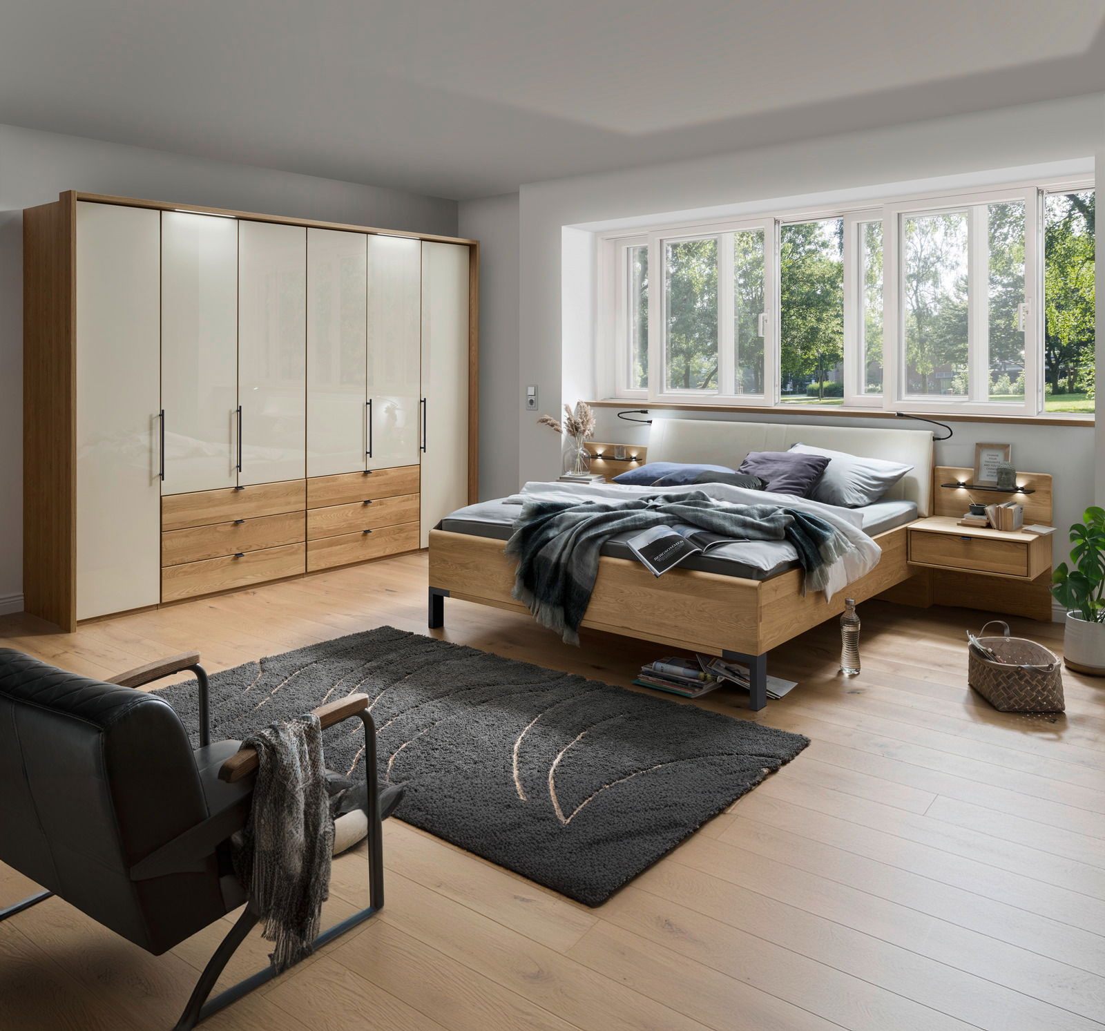 Schlafzimmer mit Dieter Knoll Gleittüren-Funktionsschrank AMATO, Futonbett und Nachtkonsolen in moderner Holzoptik, seitliche Perspektive