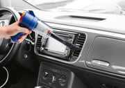Handstaubsauger in der Hand, der das Armaturenbrett eines Autos aus der Innenperspektive reinigt