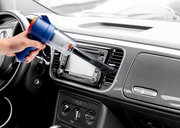 Handstaubsauger in der Hand, der das Armaturenbrett eines Autos aus der Innenperspektive reinigt