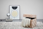 Hocker mit Stauraum in beige, geöffnet mit einer Decke darin, seitliche Perspektive