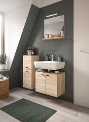 Moderne Badkombination mit Holzoptik, bestehend aus Waschbecken, Unterschrank und Spiegel, seitliche Perspektive.
