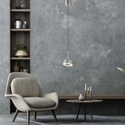 Moderne Pendelleuchte Q-ROTATE in einem stilvollen Wohnzimmer, seitliche Perspektive.