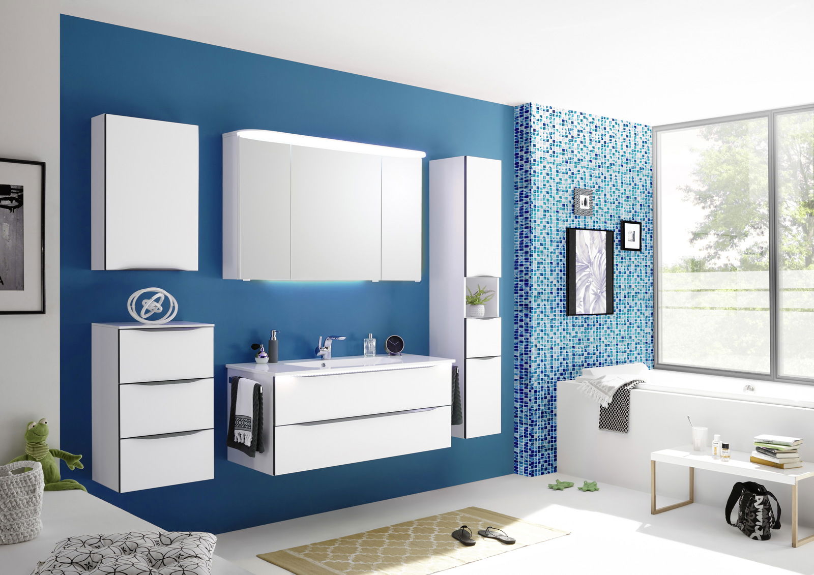 Moderne Badkombination mit weißen Schränken und Spiegeln vor einer blauen Wand, seitliche Perspektive
