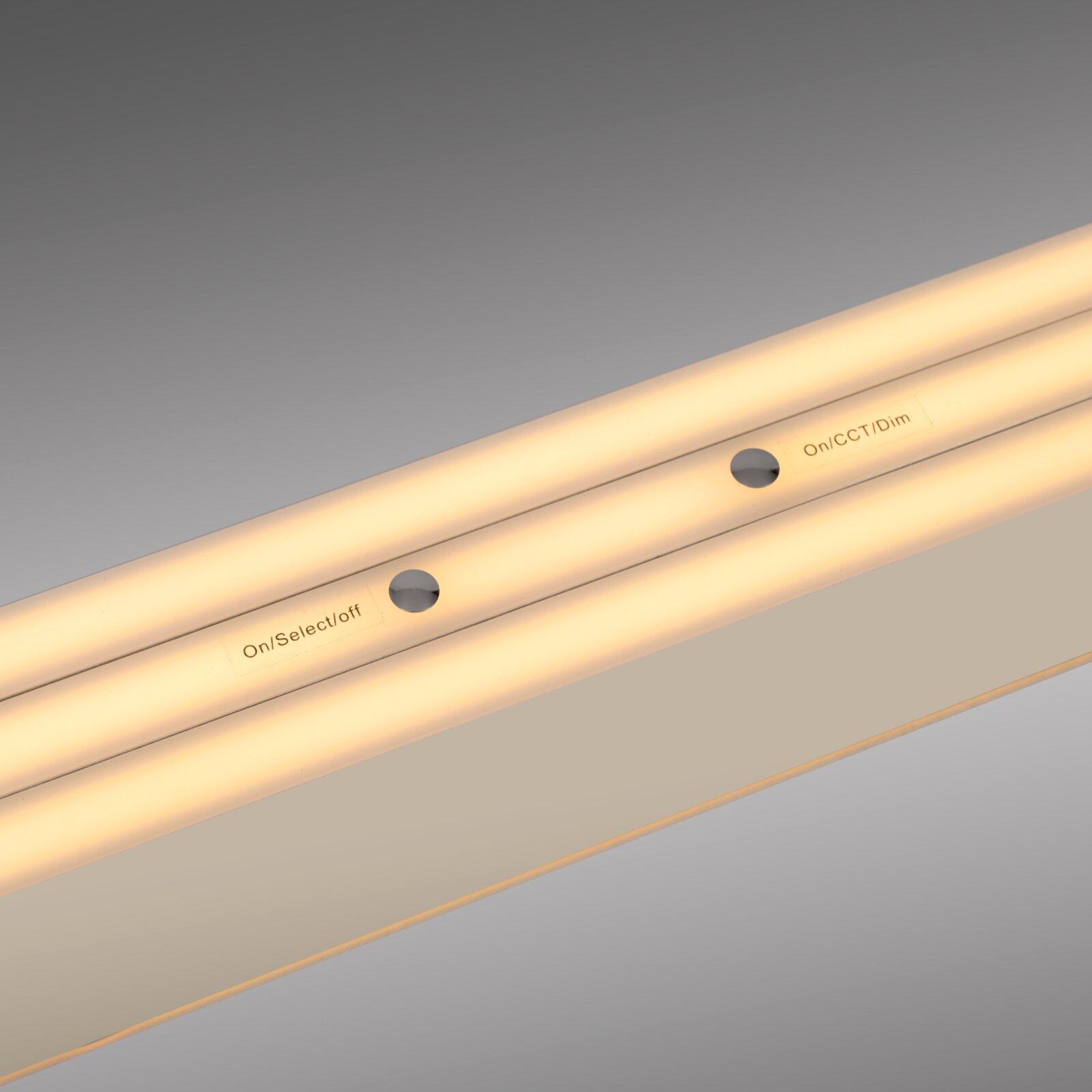 Nahaufnahme einer warmweiß leuchtenden LED-Lichtleiste mit integrierten Tasten/Öffnungen und Beschriftung „On/CCT/Dim“, diagonale Draufsicht auf das Produkt