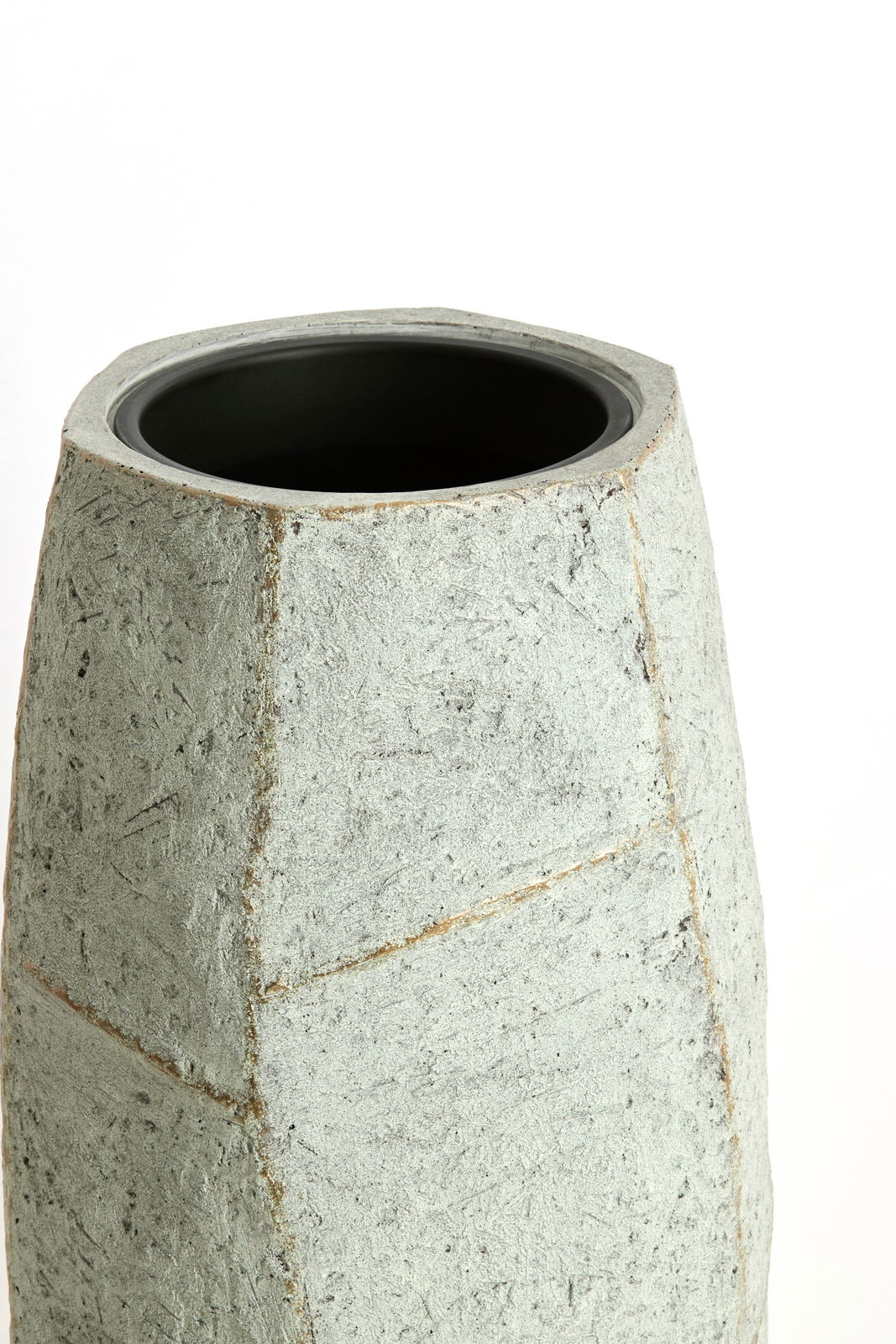 Moderner, geometrisch geformter Topf aus grauem Material, Ansicht von schräg oben.