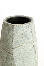 Moderner, geometrisch geformter Topf aus grauem Material, Ansicht von schräg oben.