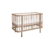 Beiges Baby-Gitterbett aus Holz mit Matratze, freigestellt auf weißem Hintergrund, in schräger Frontansicht (3/4-Perspektive) von vorne rechts.