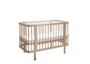 Beiges Baby-Gitterbett aus Holz mit Matratze, freigestellt auf weißem Hintergrund, in schräger Frontansicht (3/4-Perspektive) von vorne rechts.