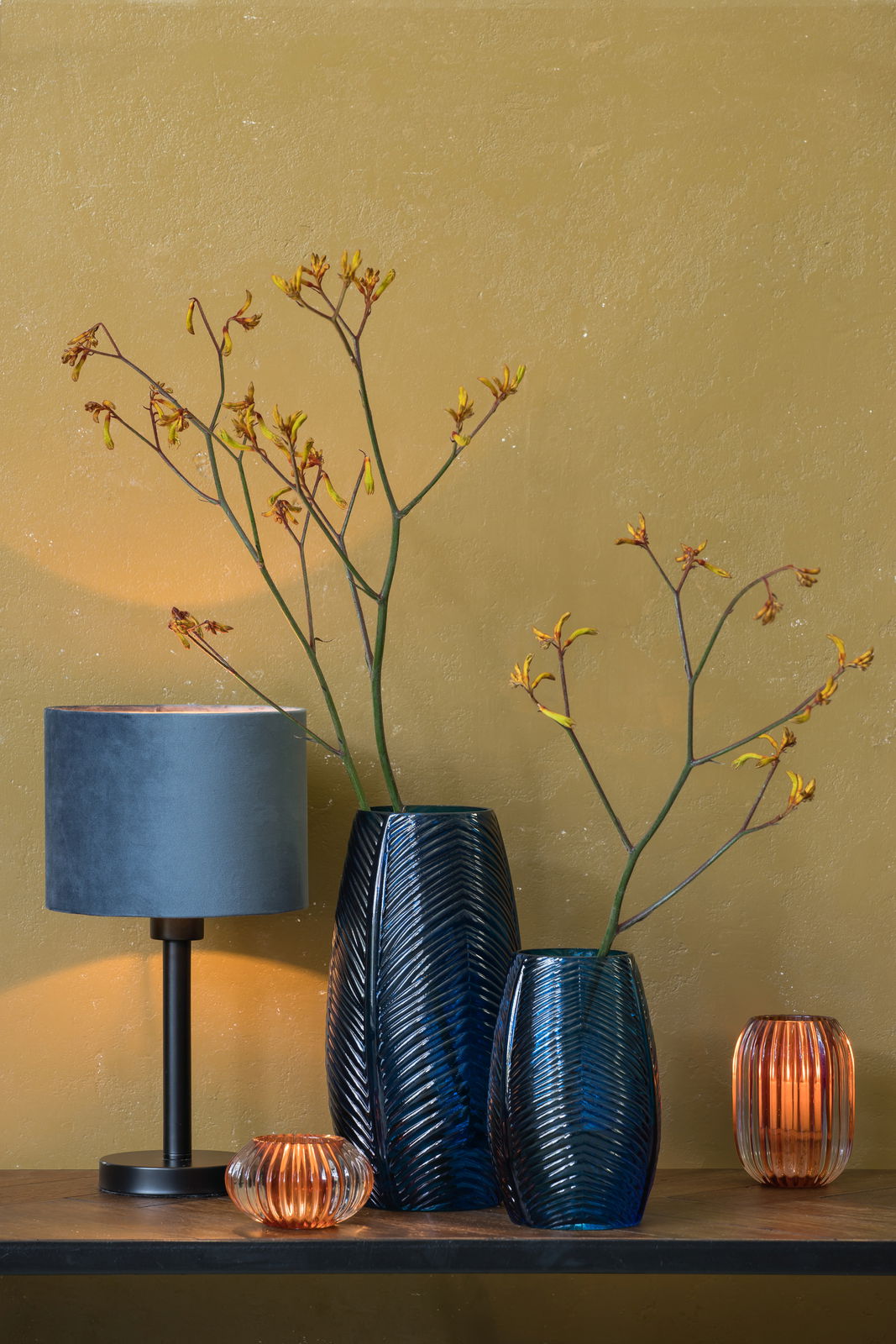 Light&Living Lampenfuß WASHINGTON Moderner Lampenfuß in Schwarz mit blauem Lampenschirm, seitliche Perspektive, umgeben von dekorativen Vasen und Kerzenhaltern auf einem Holztisch vor einer senfgelben Wand.