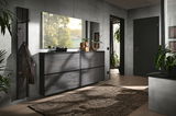Moderner Eingangsbereich mit dunklem Hängeschuhschrank, großem Wandspiegel und Wandgarderobe, aus der Perspektive des Raumes fotografiert.