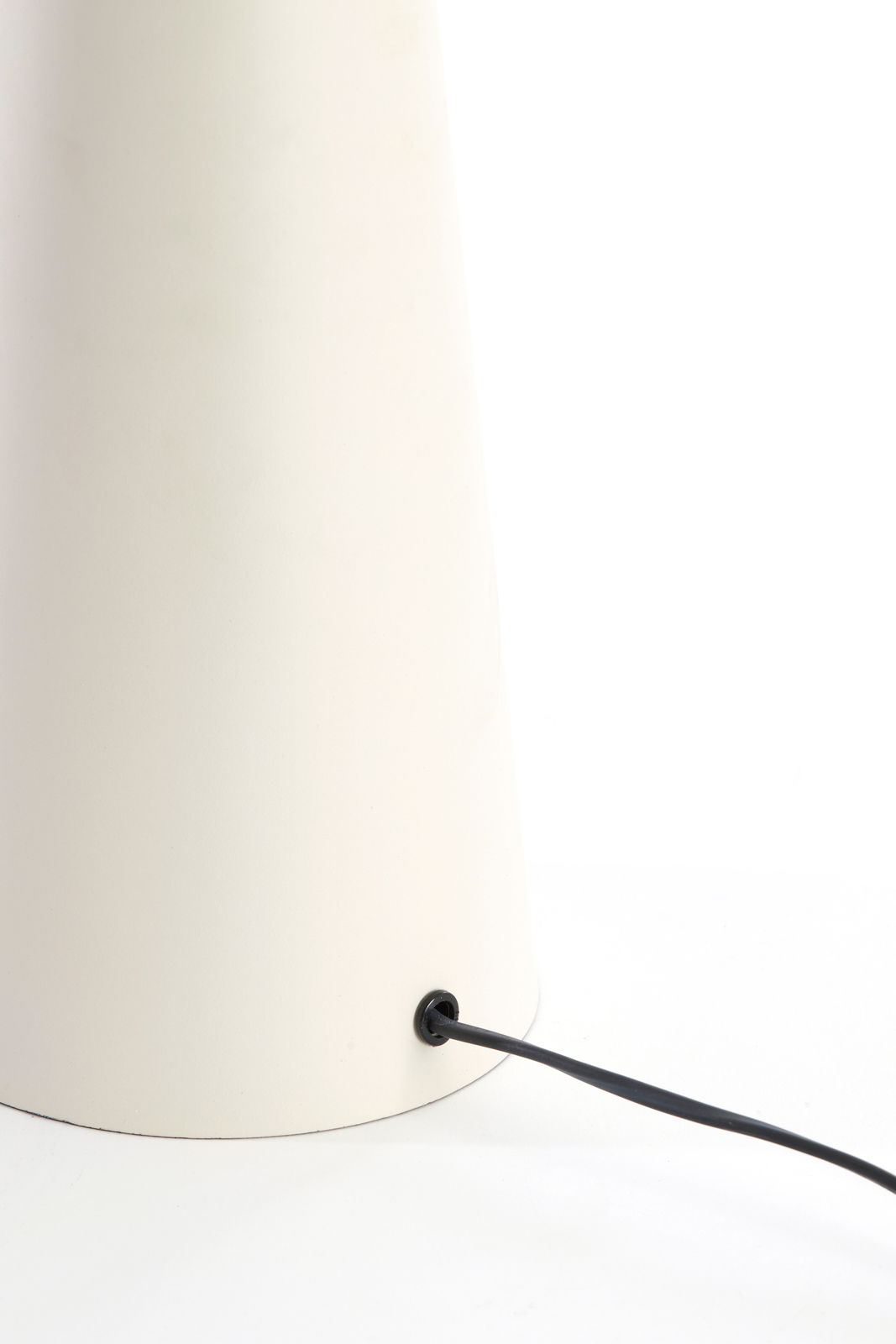 Nahaufnahme eines weißen Lampenfußes mit schwarzem Kabel, seitliche Perspektive