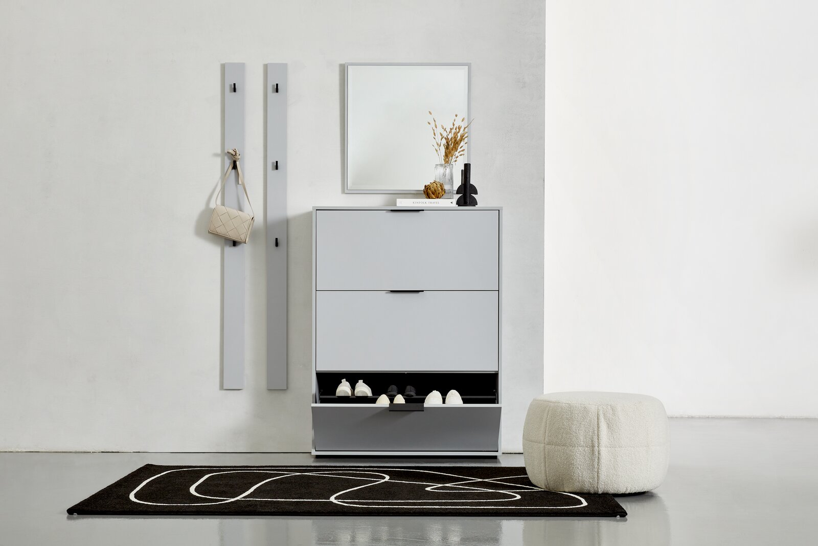 Hom´in Garderobenpaneel-Set lang JOLLY Moderner Eingangsbereich mit einem grauen Schuhkipper, zwei Garderobenpaneelen und einem Spiegel. Perspektive von vorne.