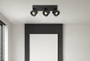 Dreifacher LED-Strahler in modernem Design, an der Decke montiert, mit schwarzem Gehäuse und warmem Licht, seitliche Perspektive.