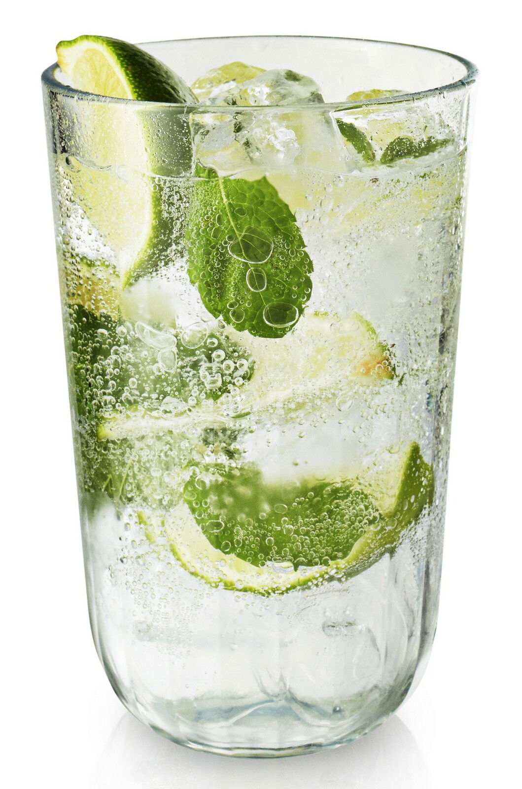 Facettenglas mit erfrischendem Getränk, Limettenscheiben und Minzblättern, seitliche Perspektive