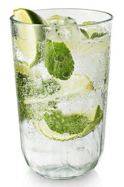 Facettenglas mit erfrischendem Getränk, Limettenscheiben und Minzblättern, seitliche Perspektive
