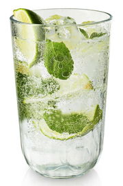 Facettenglas mit erfrischendem Getränk, Limettenscheiben und Minzblättern, seitliche Perspektive