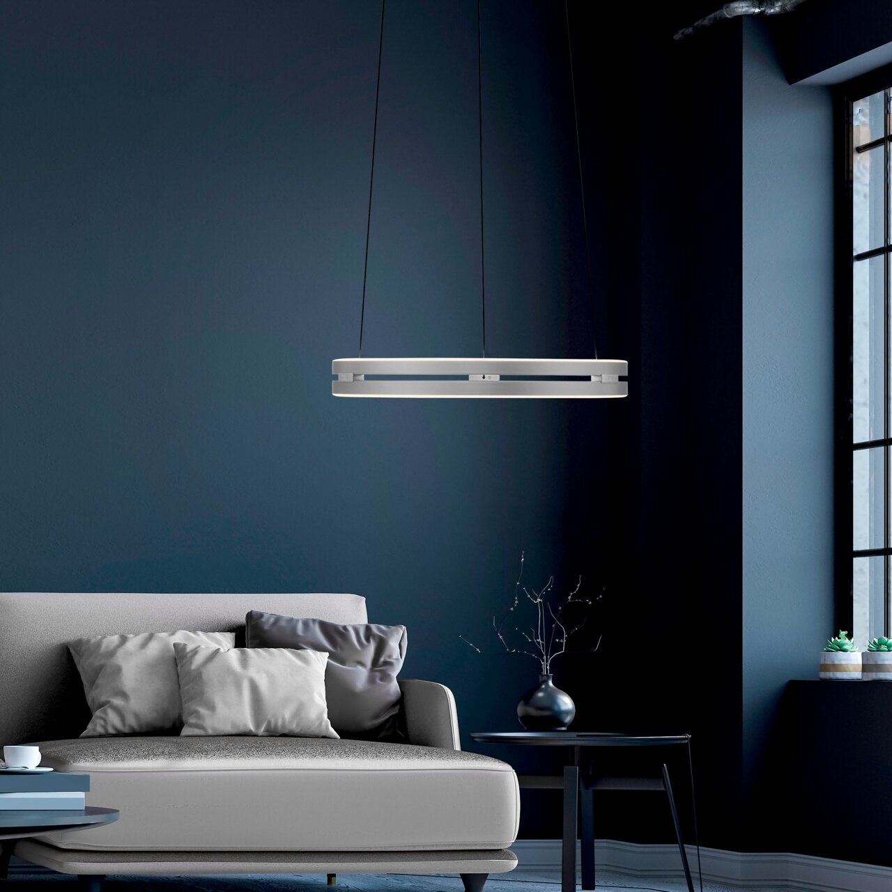 Moderne Pendelleuchte PURE E-Loop in einem stilvollen Wohnzimmer, seitliche Perspektive