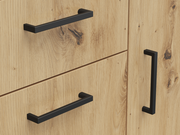 Nahaufnahme einer Kommode aus hellem Holz mit schwarzen, modernen Griffen, perspektivisch von vorne aufgenommen.