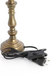 Nahaufnahme eines bronzefarbenen Lampenfußes mit Kabel und Schalter, seitliche Perspektive.