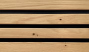 Nahaufnahme von Holzlatten mit natürlicher Maserung und Knoten, horizontal angeordnet, mit schwarzem Hintergrund.