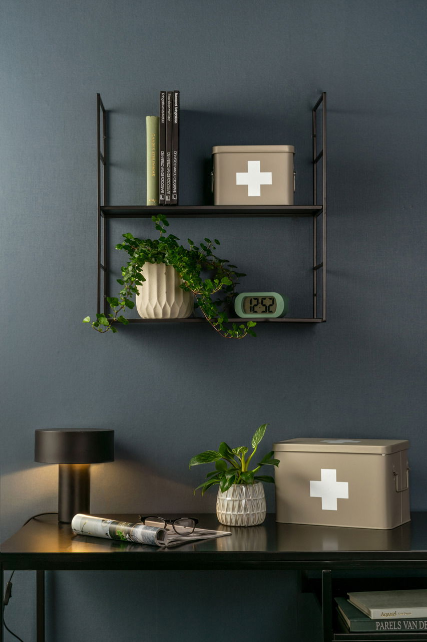 Aufbewahrungsbox MEDICINE in beige mit weißem Kreuz, auf einem Regal und Tisch in einem stilvollen Raum, seitliche Perspektive