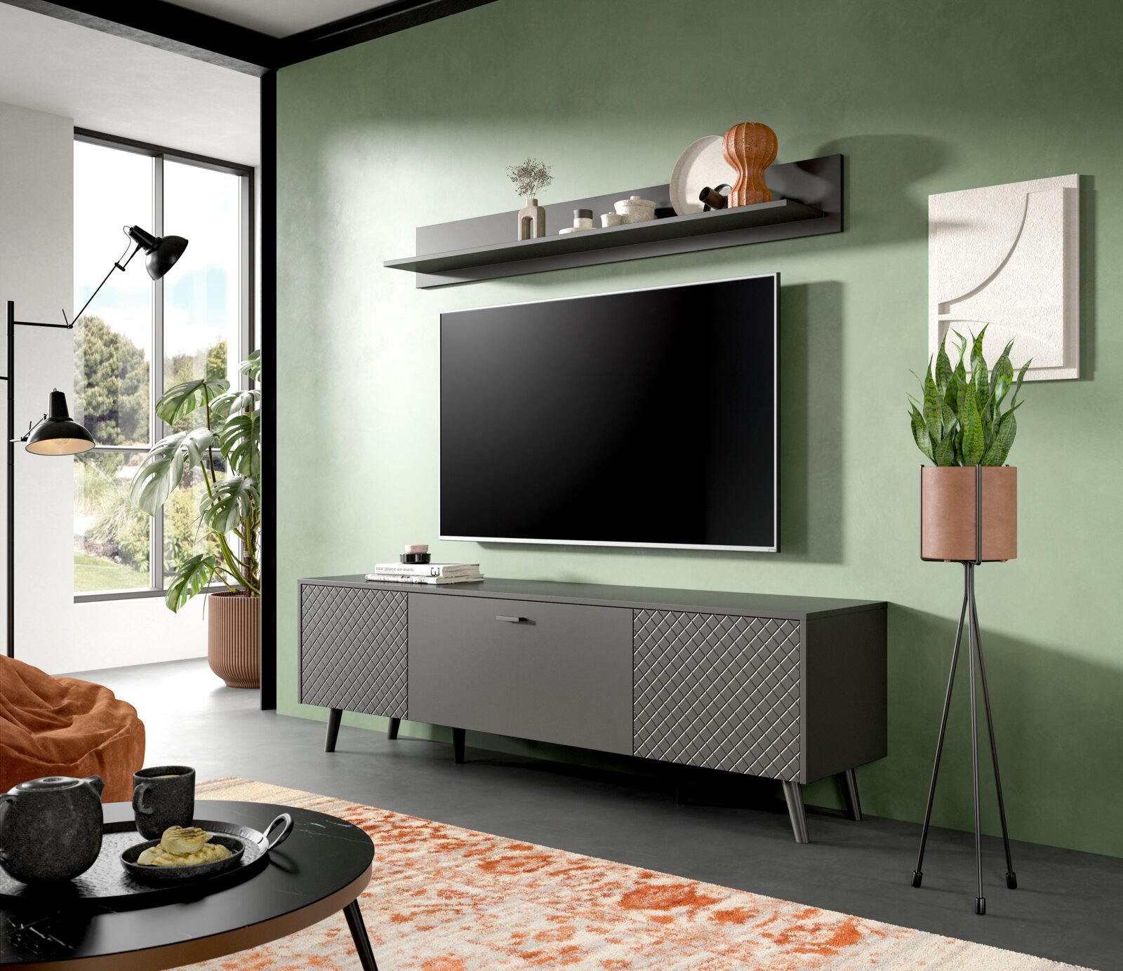 Modernes Wohnzimmer mit grün gestrichener Wand, Wandboard über einem großen Flachbildfernseher, stilvollem Sideboard und dekorativen Elementen, seitliche Perspektive.