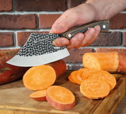 Kochmesser FARMER 14 cm schneidet Süßkartoffeln auf einem Holzbrett, seitliche Perspektive.