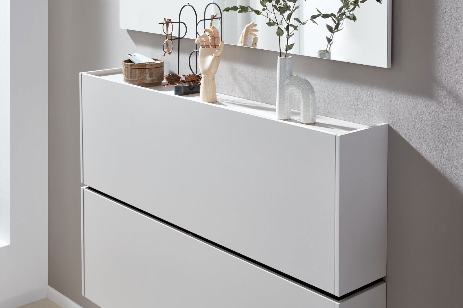 Moderner weißer Hängeschuhschrank mit Dekorationen auf der Oberseite, seitliche Perspektive
