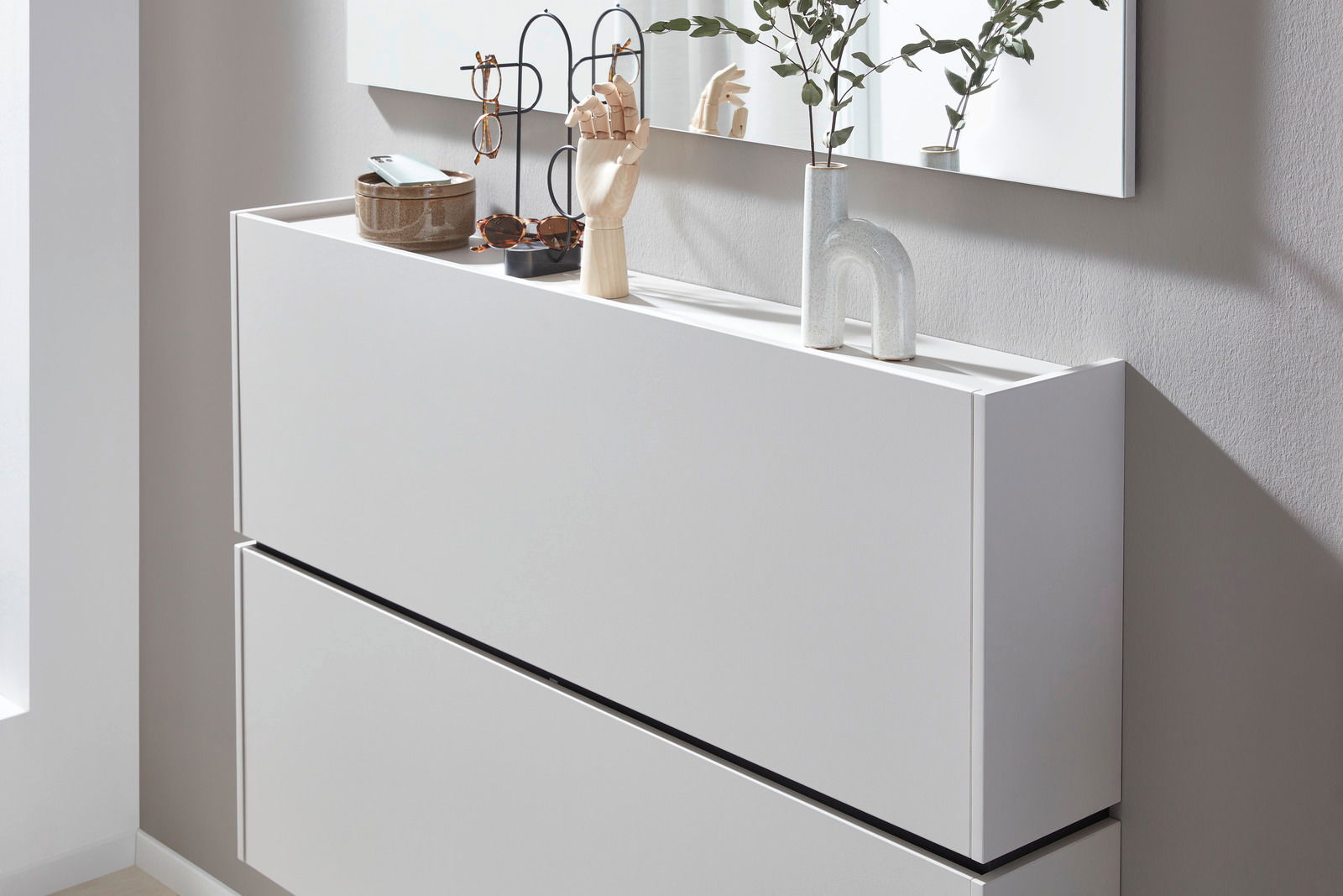 Moderner weißer Hängeschuhschrank mit Dekorationen auf der Oberseite, seitliche Perspektive