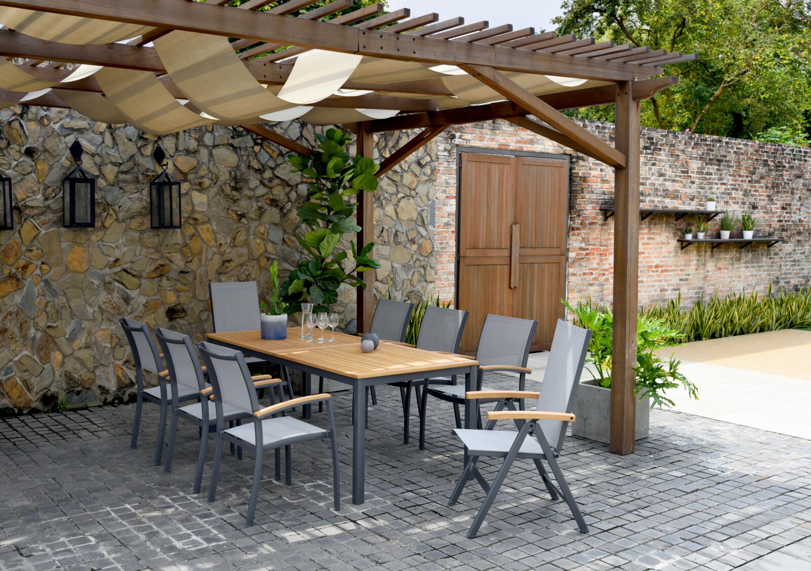 Moderne tuintafel met houten blad en grijze stoelen onder een pergola, zijaanzicht