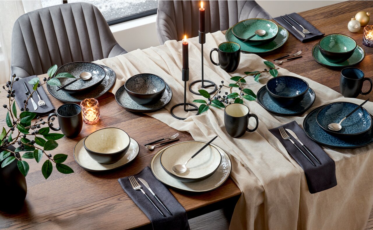Elegantes Kombiservice für sechs Personen in verschiedenen Grüntönen, auf einem festlich gedeckten Tisch mit Kerzen und Dekorationen, aus der Vogelperspektive fotografiert.