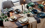Elegantes Kombiservice für sechs Personen in verschiedenen Grüntönen, auf einem festlich gedeckten Tisch mit Kerzen und Dekorationen, aus der Vogelperspektive fotografiert.