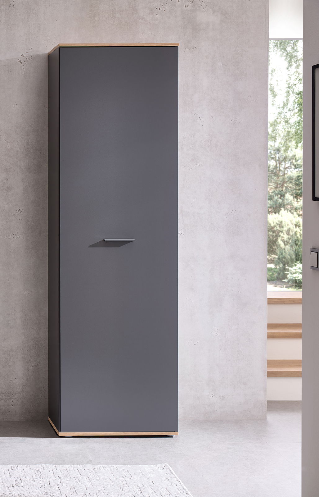 Moderner Hochschrank in dunklem Grau mit Holzdetails, frontal fotografiert in einem minimalistischen Raum.