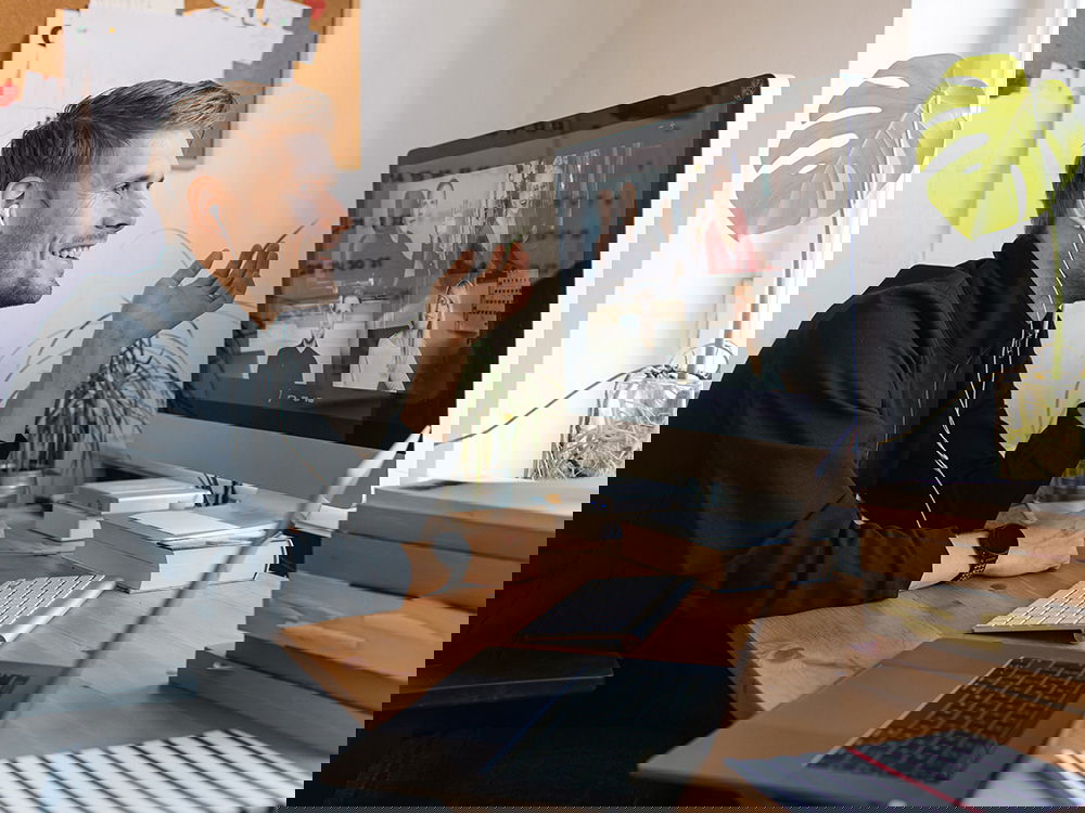 Mann im Homeoffice nimmt an einer Videokonferenz mit Kollegen teil