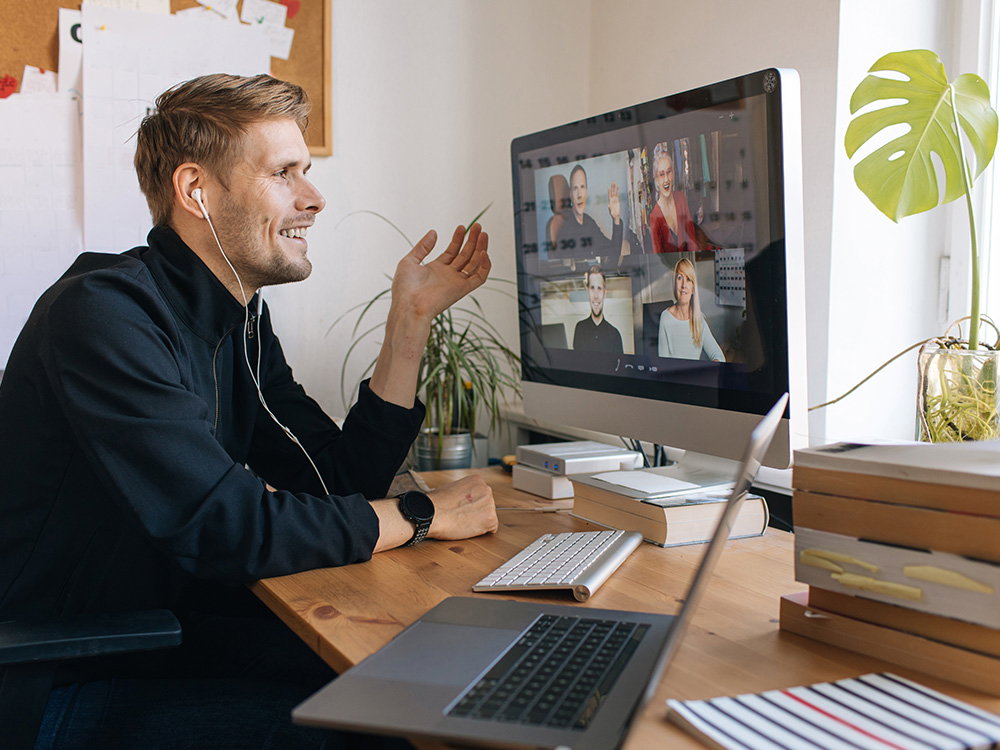 Mann im Homeoffice nimmt an einer Videokonferenz mit Kollegen teil