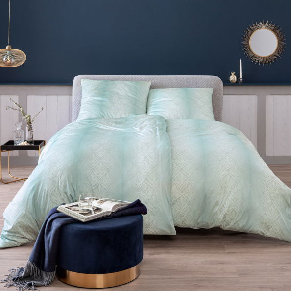 Bettwäsche-Set in sanftem Mintgrün mit geometrischem Muster, auf einem stilvoll eingerichteten Bett in einem modernen Schlafzimmer, frontal aufgenommen.