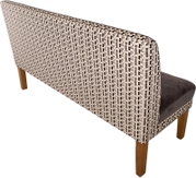 Gestoffeerde bank met hoge rugleuning, bekleed met een stof met patroon in beige/zwart en houten poten, zijaanzicht van de rugleuning vanuit een iets hoger perspectief