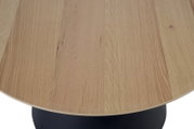 Close-up van een salontafel met een rond houten blad en een zwarte voet, gezien van bovenaf.